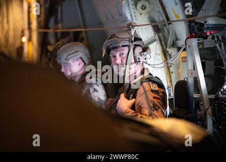 Gaza, territori palestinesi. 25 marzo 2024. I soldati siedono a bordo di un aereo da trasporto C-130 Hercules dell'Aeronautica militare tedesca in avvicinamento a Gaza per scaricare pallet di forniture di aiuti sulla Striscia di Gaza. Le forze armate tedesche stanno partecipando con altre nazioni a voli di aiuto in cui le forniture di soccorso vengono ritirate dagli aerei da trasporto. Credito: Boris Roessler/dpa/Alamy Live News Foto Stock