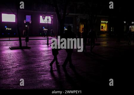 22 marzo 2024, Odessa, Ucraina: La gente cammina lungo la buia via Deribasovskaya, alla luce delle vetrine alimentate dai generatori. Un massiccio attacco missilistico contro l'Ucraina avvenne nelle ore mattutine del 22 marzo 2024. Kharkiv, Zaporizhzhia, Kryvyi Rih, Khmelnytskyi, Poltava Oblast, Vinnytsia Oblast, Lviv Oblast, Ivano-Frankivsk Oblast, Mykolaiv Oblast, Odesa Oblast, l'Oblast' di Sumy e altre parti del paese furono sottoposte al fuoco di razzi da parte dell'esercito russo. La stazione idroelettrica Dnieper fu messa fuori servizio (otto missili colpirono; un filobus che trasportava civili che viaggiavano lungo il fiume Foto Stock