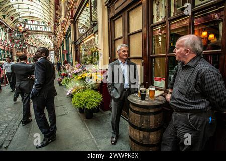 Persone di bere al di fuori della Luna Nuova casa pubblica nel mercato Leadenhall, London, England, Regno Unito Foto Stock