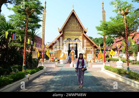 Viaggiatori thailandesi le donne viaggiano visitano il rispetto pregare benedire il mito dei desideri il culto sacro mistico e l'antica statua del buddha di Phra Sing di Wat Phra Sing Foto Stock