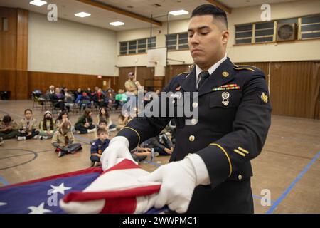 I soldati dell'esercito degli Stati Uniti con Able Company, Recruiting and Retention Battalion, New Jersey Army National Guard, insegnano ai Cub Scouts come piegare correttamente la bandiera americana in una cerimonia funebre militare a Conlon Hall, Bergen Field, New Jersey, 6 febbraio 2024. Si ritiene che l'insegnamento della cerimonia di ripiegamento della bandiera ai Cub Scouts of America insegnerà ai giovani di Bergenfield la storia e le tradizioni coinvolte nel rendere onore ad un funerale. Guardia Nazionale dell'esercito Foto Stock