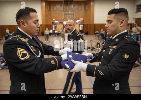 I soldati dell'esercito degli Stati Uniti con Able Company, Recruiting and Retention Battalion, New Jersey Army National Guard, insegnano ai Cub Scouts come piegare correttamente la bandiera americana in una cerimonia funebre militare a Conlon Hall, Bergen Field, New Jersey, 6 febbraio 2024. Si ritiene che l'insegnamento della cerimonia di ripiegamento della bandiera ai Cub Scouts of America insegnerà ai giovani di Bergenfield la storia e le tradizioni coinvolte nel rendere onore ad un funerale. Guardia Nazionale dell'esercito Foto Stock