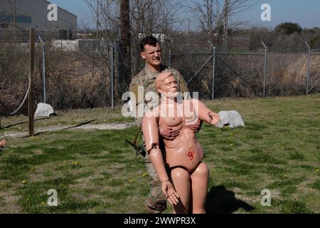Il sergente dell'esercito statunitense Connor Lauster, assegnato alla C Company, 15th Brigade Support Battalion, 2nd Armored Brigade Combat Team, 1st Cavalry Division conduce cure tattiche sul campo spostando il manichino in un luogo sicuro presso il Medical Simulation Training Center, a Fort Cavazos, Texas, 22 febbraio 2024. La simulazione faceva parte di una serie di eventi progettati per preparare i soldati alla competizione Army Best Medic Competition a Fort Liberty, Carolina del Nord. Esercito Foto Stock