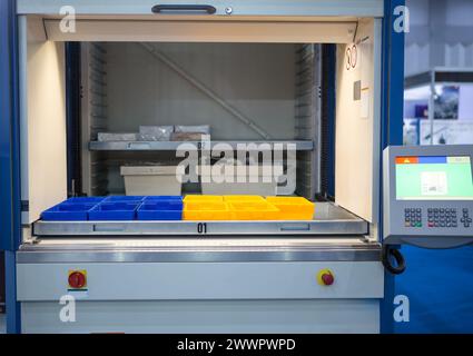 Soluzione ergonomica per lo stoccaggio verticale. Sistema di archiviazione e recupero automatizzato. Moderno magazzino industriale. Foto Stock