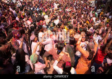 Guwahati, Assam, India. 25 marzo 2024. I rivelatori che ballano al ritmo della musica mentre celebrano Holi su una strada, il festival primaverile indù dei colori il 25 marzo 2024 a Guwahati, Assam, India. Holi, noto anche come Festival dei colori o Festival della primavera, è uno dei festival più vivaci e gioiosi dell'India. Crediti: David Talukdar/Alamy Live News crediti: David Talukdar/Alamy Live News Foto Stock