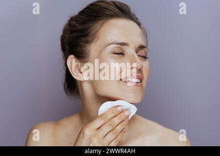 donna moderna sorridente con tampone di cotone isolato su sfondo blu. Foto Stock