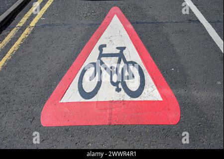 Guardando verso il basso un cartello rosso a triangolo dipinto su un avvertimento stradale per i conducenti di essere a conoscenza dei ciclisti, Regno Unito Foto Stock