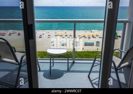 Una splendida vista dal piano superiore della camera dell'hotel, attraverso la porta del balcone aperta, che si affaccia sulla spiaggia di sabbia di Miami Beach. Foto Stock