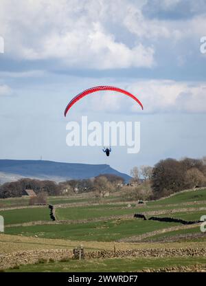 Parapendio in arrivo su terreni agricoli vicino a Hawes nello Yorkshire Dales National Park, Regno Unito. Foto Stock