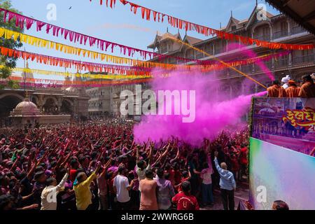 25 marzo 2024, Ahmedabad, Gujarat, India: Migliaia di devoti applaudirono mentre polvere colorata e acqua venivano spruzzate da un sacerdote su di loro durante le celebrazioni del colorato festival Holi presso il tempio Swaminarayan a Kalupur, nella vecchia Ahmedabad. Holi è una delle antiche feste indù, celebrata nel giorno della luna piena del falgun indù, mese primaverile (marzo), che segna il trionfo del bene sul male, la rimozione della negatività, onora la fertilità, il legame, dimenticando la vecchia inimicizia, diffondere l'amore. Mentre si festeggia la gente spalma i colori a base di polvere profumata sul viso. (Immagine di credito: © S Foto Stock