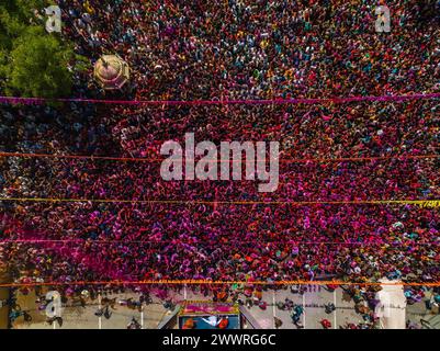 25 marzo 2024, Ahmedabad, Gujarat, India: Migliaia di devoti applaudirono mentre polvere colorata e acqua venivano spruzzate da un sacerdote su di loro durante le celebrazioni del colorato festival Holi presso il tempio Swaminarayan a Kalupur, nella vecchia Ahmedabad. Holi è una delle antiche feste indù, celebrata nel giorno della luna piena del falgun indù, mese primaverile (marzo), che segna il trionfo del bene sul male, la rimozione della negatività, onora la fertilità, il legame, dimenticando la vecchia inimicizia, diffondere l'amore. Mentre si festeggia la gente spalma i colori a base di polvere profumata sul viso. (Immagine di credito: © S Foto Stock