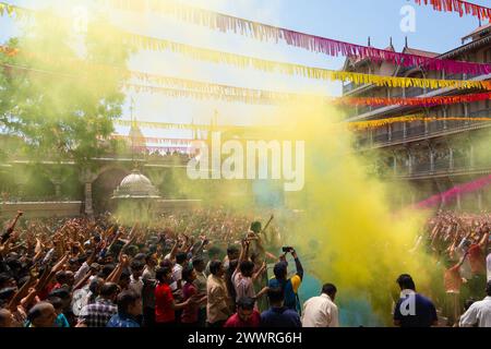 25 marzo 2024, Ahmedabad, Gujarat, India: Migliaia di devoti applaudirono mentre polvere colorata e acqua venivano spruzzate da un sacerdote su di loro durante le celebrazioni del colorato festival Holi presso il tempio Swaminarayan a Kalupur, nella vecchia Ahmedabad. Holi è una delle antiche feste indù, celebrata nel giorno della luna piena del falgun indù, mese primaverile (marzo), che segna il trionfo del bene sul male, la rimozione della negatività, onora la fertilità, il legame, dimenticando la vecchia inimicizia, diffondere l'amore. Mentre si festeggia la gente spalma i colori a base di polvere profumata sul viso. (Immagine di credito: © S Foto Stock