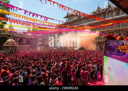 25 marzo 2024, Ahmedabad, Gujarat, India: Migliaia di devoti applaudirono mentre polvere colorata e acqua venivano spruzzate da un sacerdote su di loro durante le celebrazioni del colorato festival Holi presso il tempio Swaminarayan a Kalupur, nella vecchia Ahmedabad. Holi è una delle antiche feste indù, celebrata nel giorno della luna piena del falgun indù, mese primaverile (marzo), che segna il trionfo del bene sul male, la rimozione della negatività, onora la fertilità, il legame, dimenticando la vecchia inimicizia, diffondere l'amore. Mentre si festeggia la gente spalma i colori a base di polvere profumata sul viso. (Immagine di credito: © S Foto Stock