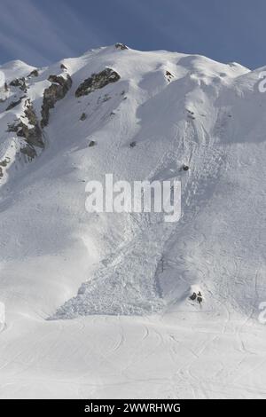 Una valanga controllata, avviata da esperti di piste per garantire la sicurezza dei vacanzieri nella località sciistica di Tignes, nelle Alpi francesi. Foto Stock