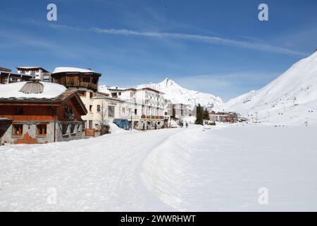 Alloggi turistici in stile tradizionale e anni '1960 si affacciano sul lago di Tignes, una stazione sciistica delle Alpi francesi dominata dalla cima del grande Sassière. Foto Stock