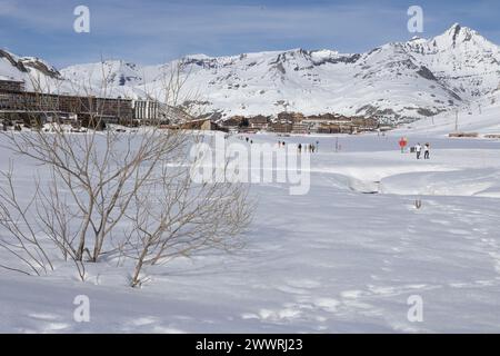 La vetta dell'Aiguille de la grande Sassière nelle Alpi francesi domina il lago ghiacciato e la stazione sciistica appositamente costruita di Tignes le Lac. Foto Stock