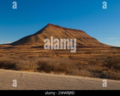 Strada ghiaiosa e montagna tabella nel sud della Namibia Foto Stock