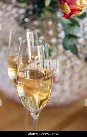 Due bicchieri di champagne con fiori sullo sfondo Foto Stock
