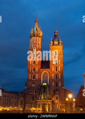 St Chiesa di Maria con due torri diverse di notte (Cracovia, Polonia). Vista frontale. Foto Stock