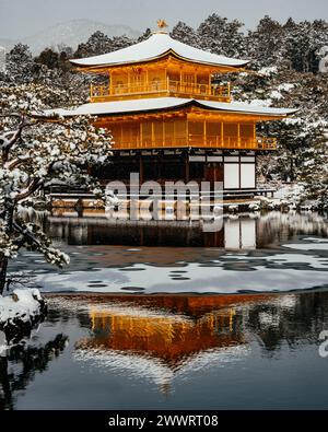 La pagoda dorata buddista zen (Kinkakuji) di Kyoto, in Giappone, coperta di neve con riflessi nel lago. La zona è coperta da una neve pesante e rara. Foto Stock