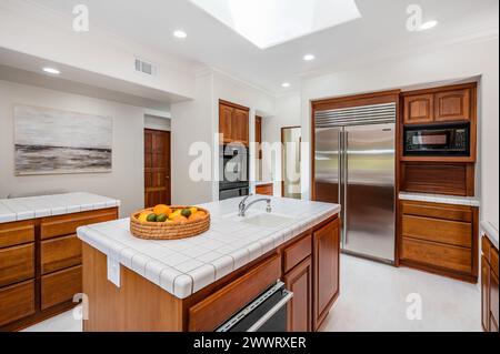 Cesto di frutta fresca su Kitchen Island nel cuore di una cucina luminosa Foto Stock