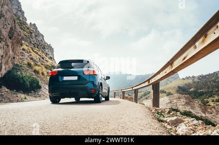 Auto compatta e veloce su strada asfaltata con protezione stradale in acciaio. Viaggiando sull'isola di Maiorca in Spagna, noleggiando un'auto o la sicurezza Foto Stock