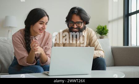 Sorridente arabo indiano coppia d'affari musulmano uomo donna parlare online videochiamata webcam laptop conferenza lontano riunione a casa ufficio multirazziale ragazzo Foto Stock