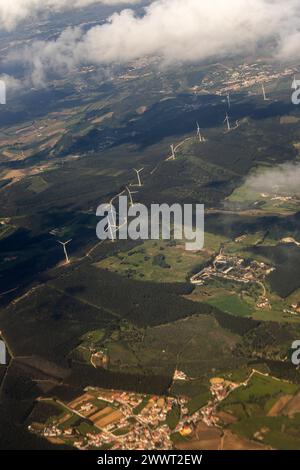 Lisbona, Portogallo. 13 marzo 2024. Le turbine eoliche punteggiano il paesaggio sottostante visto dalla finestra di un aereo, sfruttando l’energia rinnovabile. Foto Stock