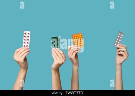 Mani femminili che tengono pillole in blister su sfondo blu Foto Stock