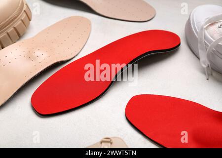 Scarpe e solette ortopediche su sfondo bianco Foto Stock