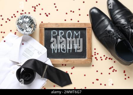 Lavagna con testo PROM NIGHT, scarpe maschili e camicia su sfondo beige Foto Stock