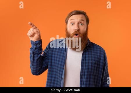 Divertente ritratto di un uomo dai capelli rossi sorpreso con la barba che punta da parte Foto Stock