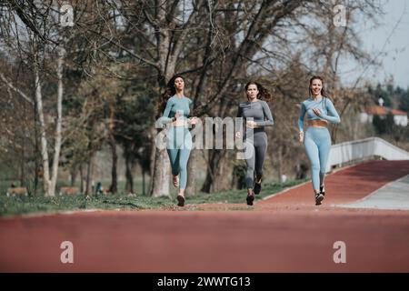 Tre donne che fanno jogging in un parco in una giornata di sole, mostrando fitness e salute Foto Stock