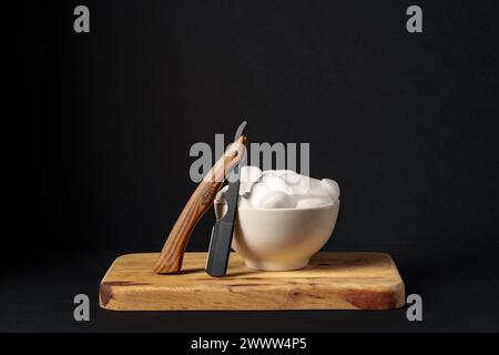 Apparecchiatura di rasatura classica con rasoio, spazzola e sapone su supporto in legno su sfondo scuro Foto Stock