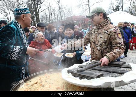 Non esclusiva: KIEV, UCRAINA - 23 MARZO 2024 - l'uomo tratta pilaf ai partecipanti alle celebrazioni del Solstizio ucraino e del Nauryz turco fuori dal Foto Stock