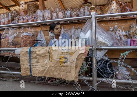 Visitatori, commercianti e immigrati birmani illegali tramite filo spinato sul lato thailandese del confine tra Thailandia e Myanmar a Mae Sot, Thailandia Foto Stock