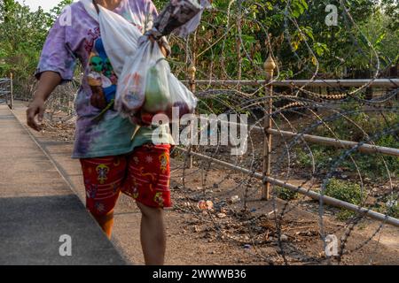 Visitatori, commercianti e immigrati birmani illegali tramite filo spinato sul lato thailandese del confine tra Thailandia e Myanmar a Mae Sot, Thailandia Foto Stock