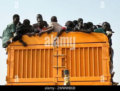 Renk, Sudan del Sud. 20 marzo 2024. I rifugiati provenienti dal Sudan vengono portati in camion dalla città di confine di Renk, nel Sudan del Sud, a un molo per continuare il loro viaggio verso la loro prossima destinazione. La lotta di potere in Sudan, in corso dalla metà di aprile 2023, ha scatenato la più grande crisi mondiale dei rifugiati, secondo le Nazioni Unite, con più di otto milioni di rifugiati. Mentre molte di queste persone cercano sicurezza dai combattimenti in Sudan, altre sono fuggite nei paesi vicini del Sudan del Sud o del Ciad. Crediti: Eva-Maria Krafczyk/dpa/Alamy Live News Foto Stock