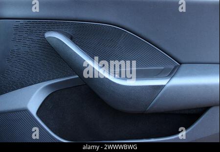 Maniglia e tasca sul pannello interno della portiera di un'auto Foto Stock