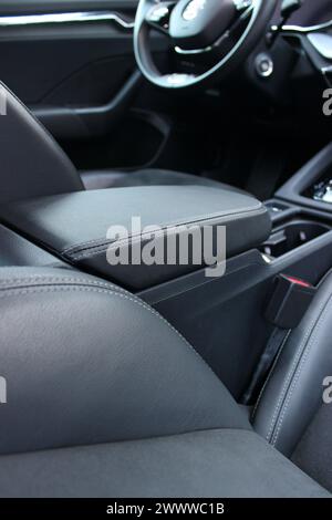 Vista posteriore in pelle nera e rivestimenti in alcantara sui sedili e sul bracciolo degli interni dell'auto Foto Stock