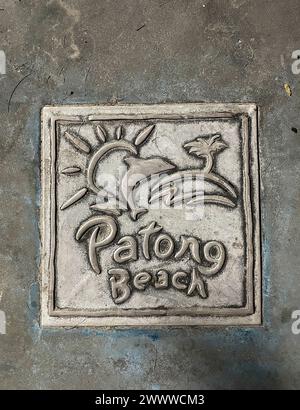 Piastrelle marciapiede con logo Patong Beach su un marciapiede di una strada a Patong, Phuket, Thailandia Foto Stock