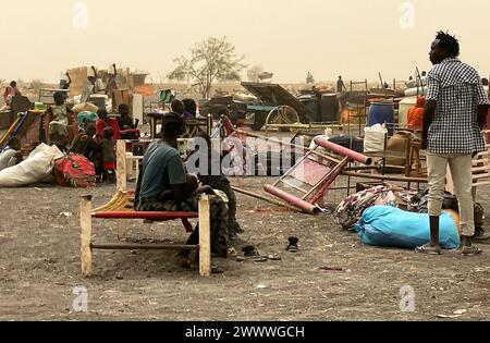 Joda, Sudan del Sud. 19 marzo 2024. I rifugiati provenienti dal Sudan attendono dietro il valico di frontiera di Joda con i loro effetti personali per continuare il loro viaggio verso la città di confine meridionale sudanese di Renk. La lotta di potere in Sudan, in corso dalla metà di aprile 2023, ha scatenato la più grande crisi mondiale dei rifugiati, secondo le Nazioni Unite, con più di otto milioni di rifugiati. Mentre molte di queste persone cercano sicurezza dai combattimenti in Sudan, altre sono fuggite nei paesi vicini del Sudan del Sud o del Ciad. Crediti: Eva-Maria Krafczyk/dpa/Alamy Live News Foto Stock