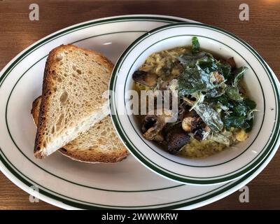 Recipiente riempito di zuppa e pane su un tavolo Foto Stock