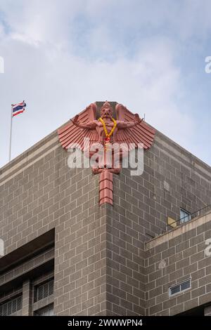 Vista verticale dettagliata di garuda o rilievo khrut e bandiera thailandese sulla facciata dell'antico Ufficio postale generale, noto anche come Grand Postal Building Foto Stock