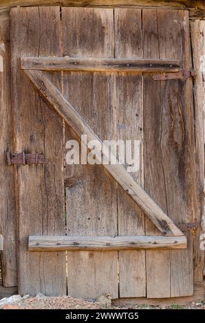 vecchia porta in tavole di legno, con cerniere e serrature in ferro, bellissime texture in legno Foto Stock