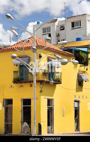 109 facciata di una casa coloniale gialla risalente al 1776 d.C. all'angolo di Chacon e Aguacate Street, palo per lampade multi-luce davanti ad essa. L'Avana vecchia-Cuba. Foto Stock