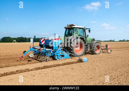 Piantine di canapa organica, trattore con spandiconcime Lemken Foto Stock