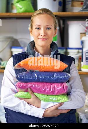 Donna, sacchetto e plastica in fabbrica, produzione di pellet e coloranti ed ecologia in verticale in negozio. Persona, colore e dipendente per il riciclaggio presso l'impianto Foto Stock