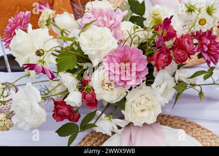 Bouquet vivace con mix di dahlias rosa e rose bianche. Ispirazione floreale e arte botanica. Foto Stock