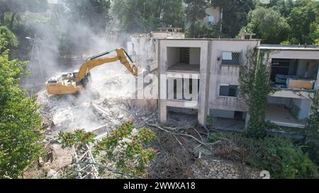 Braccio dell'escavatore che demolisce un vecchio edificio, vista aerea Foto Stock
